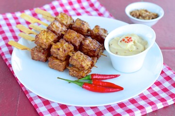 Tempeh Skewers served with spicy peanut sauce and fried onion
