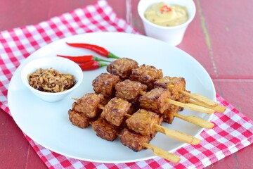 Tempeh Skewers served with spicy peanut sauce and fried onion