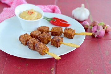 Tempeh Skewers served with spicy peanut sauce and fried onion