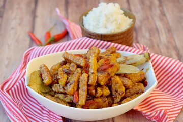 Tempe sweet soy sauce with steamed white rice on wooden background. Selective focus