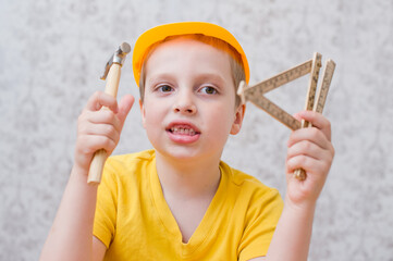 The young builder. kid with construction helmet little hammer and wooden meter