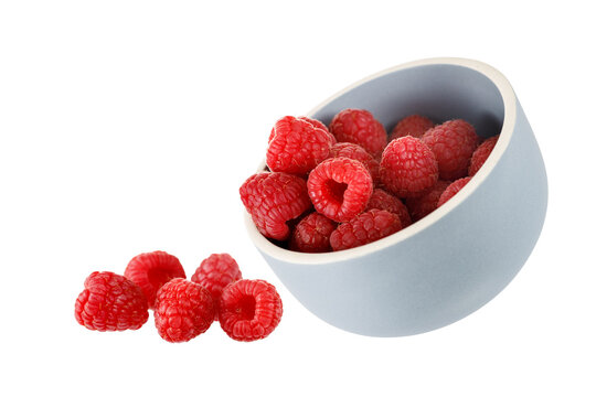 Fresh raspberries falling from bowl isolated on white background
