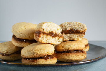 Alfahores cookies with condensed milk on a gray plate. Traditional homemade biscuits. Homemade food concept. Horizontal orientation. Close-up.