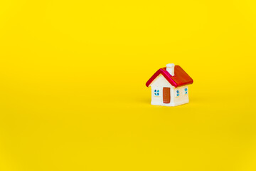 Miniature house with red roof on yellow background using as property and family concept