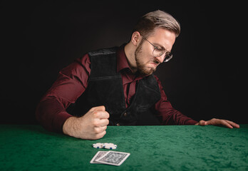Young man showing expressions while playing poker