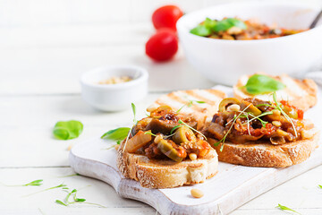 Traditional Italian Caponata and toast on a wooden white table. Sicilian caponata.