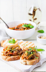 Traditional Italian Caponata and toast on a wooden white table. Sicilian caponata.