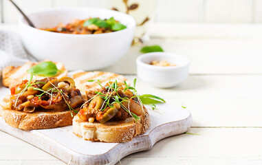 Traditional Italian Caponata and toast on a wooden white table. Sicilian caponata.