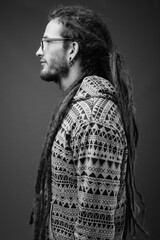 Young handsome Hispanic man with dreadlocks in black and white