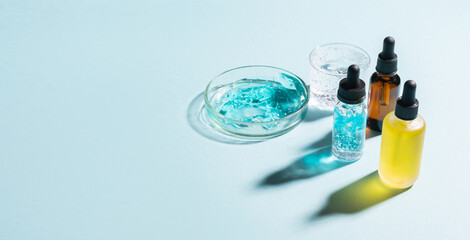 Cosmetics liquid gel serum hyaluronic acid with oxygen bubbles various vials laboratory glassware on a blue background