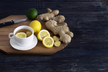 white cuo of tea with ginger and lemon on dark wooden table