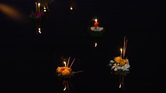 Loy Krathong festival lighting and flags decorated candles and flowers around the pool. Banana leaf krathong floating on the water in the pool .