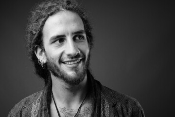 Young handsome Hispanic man with dreadlocks in black and white