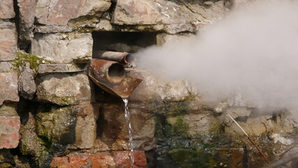rusty pipe, brick wall and hot steam