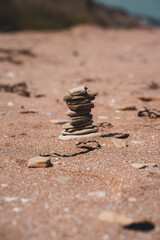 Fototapeta na wymiar A slide of stones on a sandy beach in summer