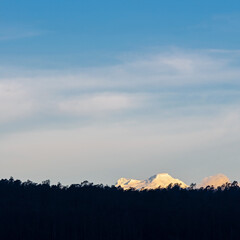 Antisana Andes peak towering above a forest at sunset, Quito, Antisana Ecological Reserve, Ecuador.