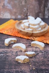 Fototapeta na wymiar Putri Salju or crescent-shaped cookies coated with powdered sugar. Traditional Indonesian cookies to celebrate Eid al Fitr. Blurred background