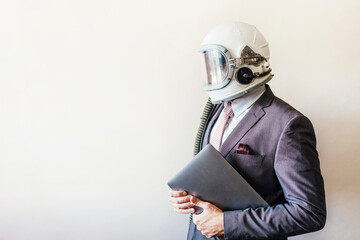 Businessman with astronaut helmet holding a laptop