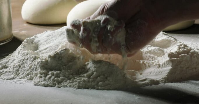 Baker hands touching flour, close up shot. Chef checking the quality of the flour before cooking bread, 4k footage 