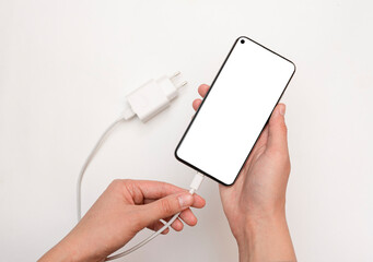 Connecting charging a smartphone via a USB cable and a power supply unit on a white background,...