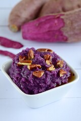 Mashed purple sweet potato with pecan nuts and maple syrup