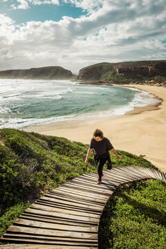 Woman hiking along the Robberg Nature Reserve coastline in South Africa. September 2019