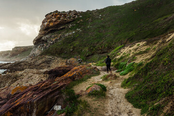 Person walking along the coastline of Robberg Nature Reserve, South Africa. 