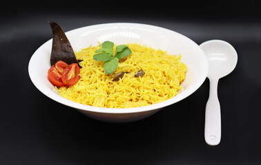 Cooked turmeric jasmine rice with powdered curcumin or Haldi, Indian food, indian basmati rice homemade with tomato and Cardamom.