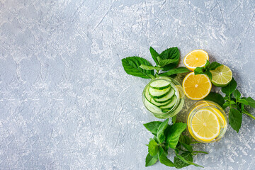 Fresh cool detox water drink with cucumber and lemon. Two glass of Lemonade with basil and mint...