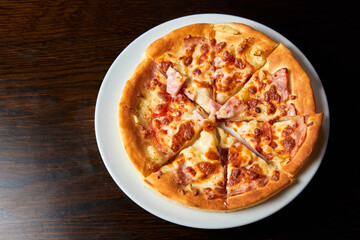 Pizza with bacon and cheese on a dark background. Close-up, selective focus
