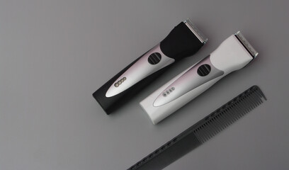 Professional Hairdressing Tools on a Gray Background. Hair Clippers and Comb. Stylized in Classic Black and White Colors With Metal Blades
