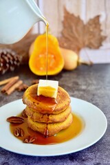Homemade pumpkin cinnamon waffle pancakes with butter and maple syrup