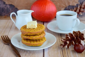 Homemade pumpkin cinnamon waffle pancakes with butter and maple syrup