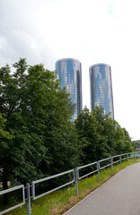 Fototapeta na wymiar Urban modern landscape with green trees and cylindrical buildings in Riga