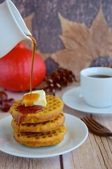 Homemade pumpkin cinnamon waffle pancakes with butter and maple syrup