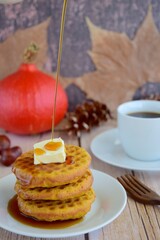 Homemade pumpkin cinnamon waffle pancakes with butter and maple syrup