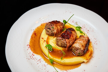 Veal kebab in bacon with mashed potatoes. Close-up, selective focus