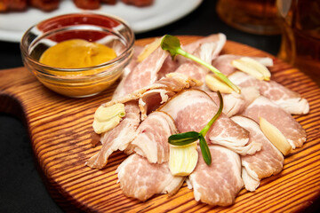 Lard with garlic and mustard on a wooden board. Close-up, selective focus