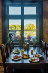 Plates with self-service breakfast on a table in restaurant. Few plates and glasses with orange juice.