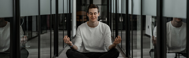 student with closed eyes meditating in hall, banner