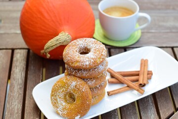 Homemade pumpkin cinnamon donuts with a cup of coffee