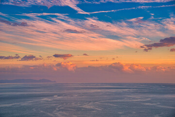 Obraz premium Beautiful cloudscape and dramatic sunset over mountain and sea.