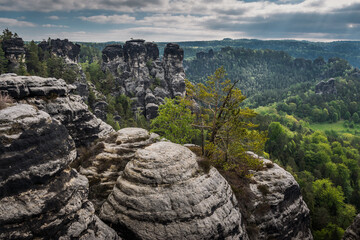 View from viewpoint of Bastei Bridge in Saxon Switzerland Germany to the town at the mountain on a cloudy day