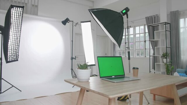 Photo Studio With Professional Equipment And Green Screen Laptop Computer Display

