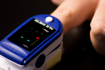 Pulse oximeter with hand of patient. Pulse Oximeter portable digital device to measure person's oxygen saturation.