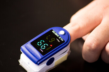 Pulse oximeter with hand of patient. Pulse Oximeter portable digital device to measure person's oxygen saturation.