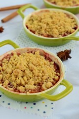 Plum crumble with spices on white background. Summer crispy fruit dessert. Tasty breakfast
