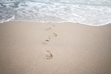 Fototapeta na wymiar footprints on the white sand of the beach