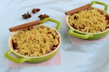 Plum crumble with spices on white background. Summer crispy fruit dessert. Tasty breakfast
