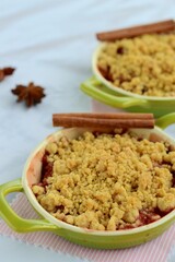 Plum crumble with spices on white background. Summer crispy fruit dessert. Tasty breakfast
